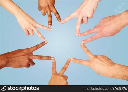diversity, race, ethnicity, international and people concept - group of hands showing peace hand sign over blue background. group of international people showing peace sign