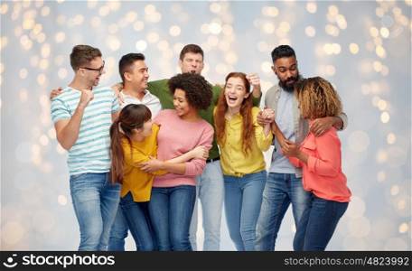 diversity, race, ethnicity, success and people concept - international group of happy smiling men and women celebrating victory over holidays lights background