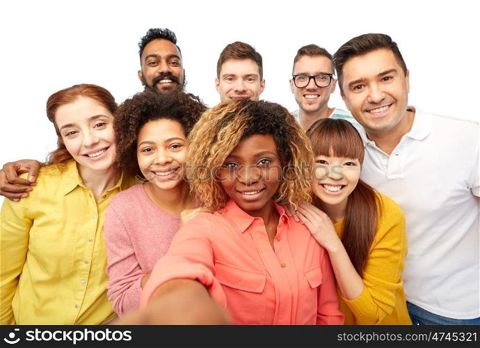 diversity, race, ethnicity, technology and people concept - international group of happy smiling men and women taking selfie over white