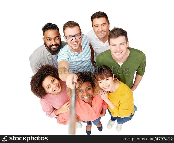 diversity, race, ethnicity, technology and people concept - international group of happy smiling men and women taking picture by selfie stick over white