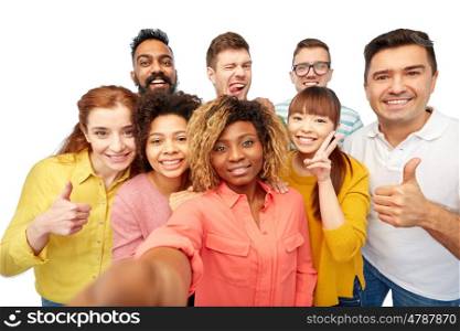 diversity, race, ethnicity, technology and people concept - international group of happy smiling men and women taking selfie over white
