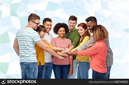 diversity, teamwork, cooperation, ethnicity and people concept - international group of happy smiling men and women holding hands together over blue low poly background