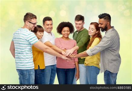 diversity, teamwork, race, ethnicity and people concept - international group of happy smiling men and women holding hands together over summer green lights background