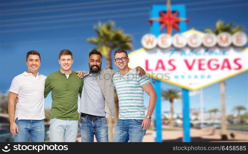 diversity, tourism and travel concept - international group of happy smiling men or friends over welcome to fabulous las vegas sign background. international male friends at las vegas