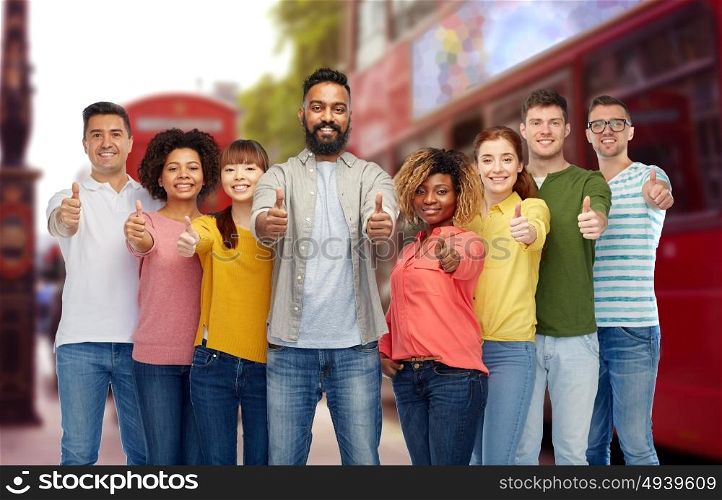 diversity, travel, tourism and people concept - international group of happy smiling men and women showing thumbs up over london street and city bus background. international people showing thumbs up at london