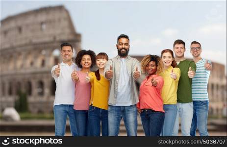 diversity, travel, tourism and people concept - international group of happy smiling men and women showing thumbs up over coliseum background. happy people showing thumbs up over coliseum