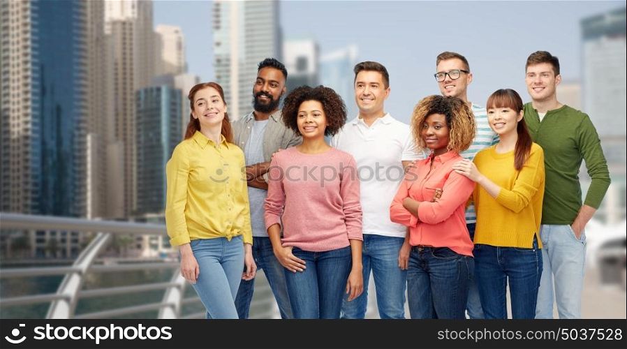 diversity, travel, tourism and people concept - international group of happy smiling men and women over dubai city background. international group of happy people in dubai