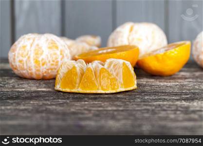 divided into small pieces and slices a tasty ripe mandarin, cut with a sharp knife into pieces, mandarin including the preparation of citrus food. tasty ripe mandarin