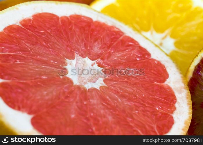 divided into small pieces and slices of different types of citrus fruits including orange, tangerines and sour pink grapefruit. different types of citrus