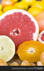 divided into small pieces and slices of different types of citrus fruits including orange, tangerines and sour pink grapefruit. different types of citrus