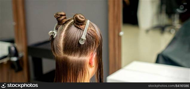 Divided women’s hair into sections with clips in the barbershop. Divided women hair in sections