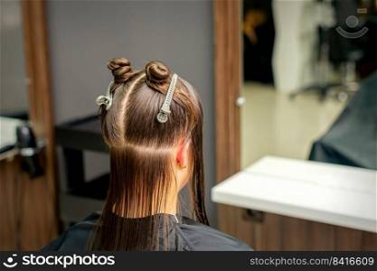 Divided women’s hair into sections with clips in the barbershop. Divided women hair in sections