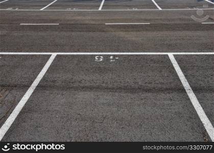 Dividing lines in empty asphalt paved parking lot abstract background.