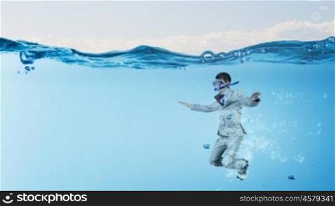 Diving businessman . Young businessman in suit and diving mask jumping in water