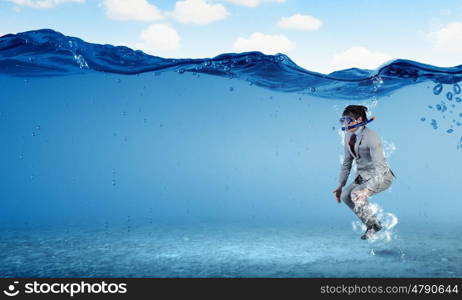 Diving businessman . Young businessman in suit and diving mask jumping in water