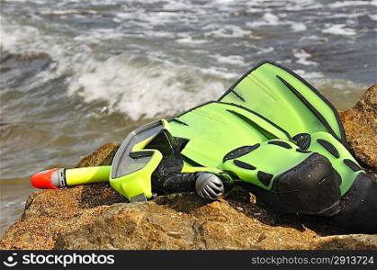 Diving mask, snorkel and flippers on seacoast. Equipment for diving