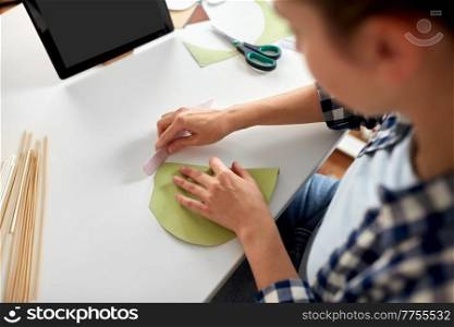 diy, art and hobby concept - close up of woman with tablet pc computer making paper craft at home. woman with tablet pc making paper craft at home