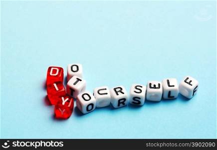 DIY Do It Yourself written on dices on blue background