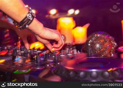DJ hands on the remote. nightclub