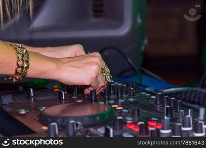 DJ hands on the remote. nightclub