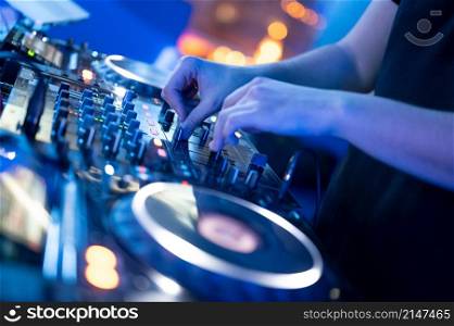 Dj mixing at party festival with light and smoke in background - Summer nightlife view of disco club inside.High quality Photography.. Dj mixing at party festival with light and smoke in background - Summer nightlife view of disco club inside.