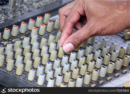 DJ mixing music on console of sound music mixer control panel