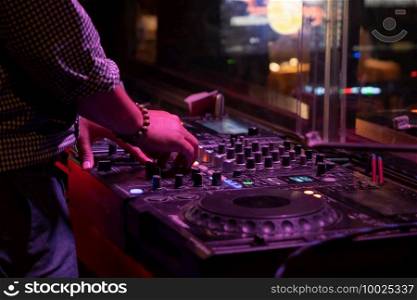 DJ plays and mixes on CD players or track at nightclub during party. Nightlife of disco club in disco pub club bar background for party music dancing festival performance. Entertainment nightlife.