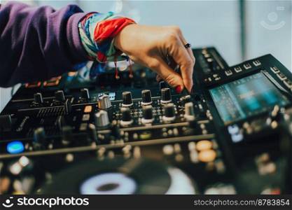 DJ plays live set and mixing music on turntable console on stage at nightclub. Disc Jockey Hands on a sound mixer station at club party. SELECT VE FOCUS