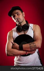 DJ with Scarfs and tatoos in front of a red background