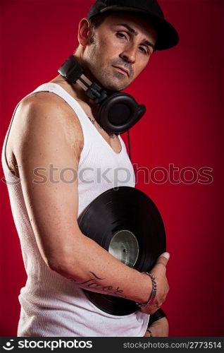 DJ with Scarfs and tatoos in front of a red background