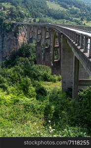 Djurdjevica Tara Bridge (opened in 1940, 172 meters above the Tara River) summer view, Montenegro. People unrecognizable.