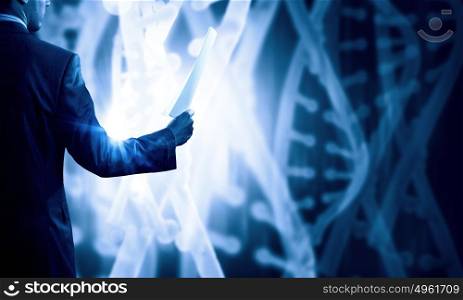 Dna research. Businessman standing with paper in hand and virtual panel with dna spiral