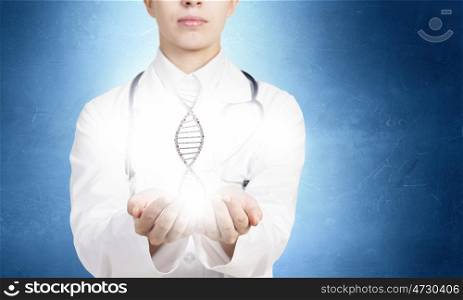 DNA research. Close up of female doctor holding DNA molecule in hands