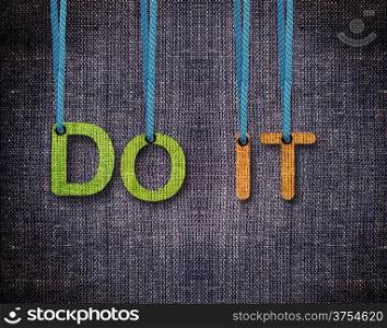 Do it Letters hanging strings with blue sackcloth background.. Do it
