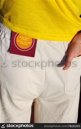 ""Do Not Disturb" hotel sign on lady&rsquo;s hip pocket in English and German"