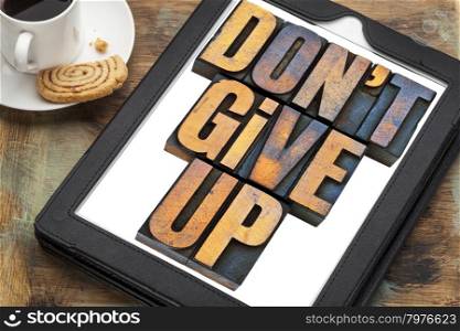 do not give up - motivation concept - a phrase in vintage letterpress wood type printing blocks on a digital tablet with a cup of coffee