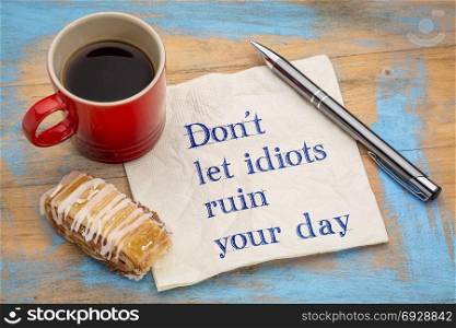 Do not let idiots ruin your day - handwrfiting on a napkin with a cup of espresso coffee and cookie