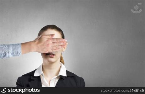 Do not look yet. Portrait of businesswoman and another person closing her eyes with palm
