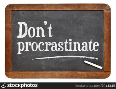 Do not procrastinate advice on a vintage slate blackboard