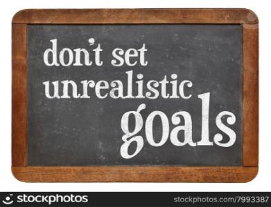 Do not set unrealistic goals - advice or reminder in white chalk on a vintage slate blackboard