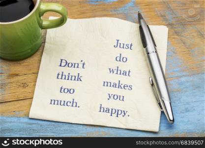 Do not think too much. Just do what makes you happy. Inspirational handwriting on a napkin with a cup of coffee.