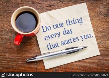 Do one thing every day that scares you - motivational handwriting on a napkin with a cup of coffee