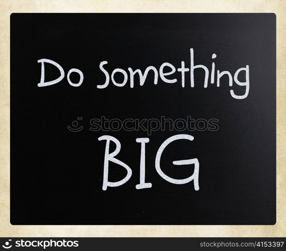 ""Do something big" handwritten with white chalk on a blackboard"