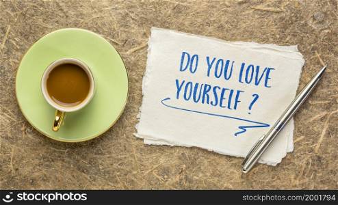 Do you love yourself? Handwriting on a handmade paper with a cup of coffee. Self respect, self care, confidence and personal development concept