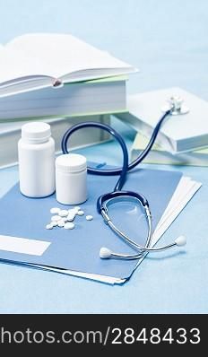 Doctor accessories with medical pills on blue background