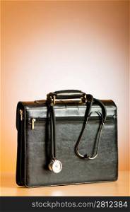 Doctor&acute;s case with stethoscope against colorful background