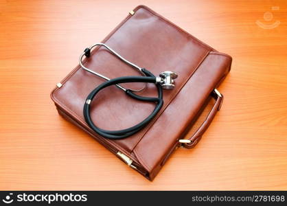 Doctor&acute;s case with stethoscope against wooden background