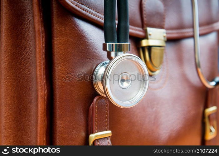 Doctor&acute;s case with stethoscope against wooden background