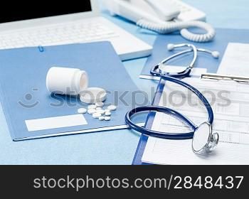 Doctor&acute;s office desk with medical supplies documents stethoscope