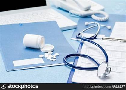 Doctor&acute;s office desk with medical supplies documents stethoscope